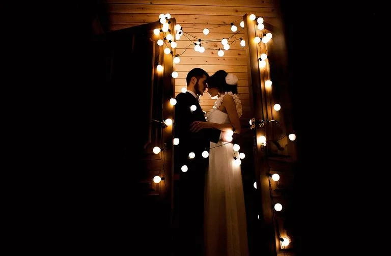 Поцелуй пары в окружении огней