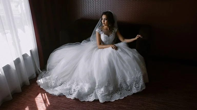 Невеста в пышном платье сидит на полу